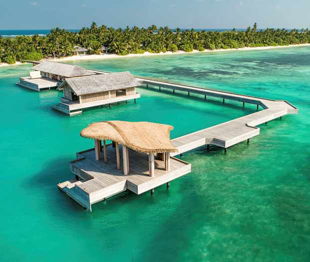 Vesi-bungalowit trooppisella rannalla, turkoosi meri. (Tekoälyn luoma teksti)