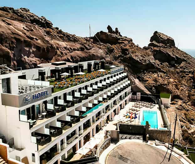 Hotelli, joka sijaitsee vuorenrinteellä ja sisältää uima-allasalueen sekä merinäköalan. (Tekoälyn luoma teksti)