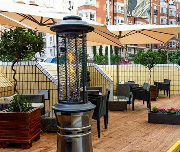 Terassi, jossa kalusteet ja lämmittimet puulattialla. (Tekoälyn luoma teksti)