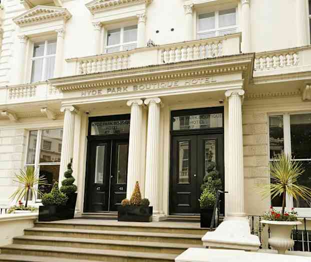 Boutique-hotellin etupuoli, jossa pääsisäänkäynti ja pylväitä. (Tekoälyn luoma teksti)