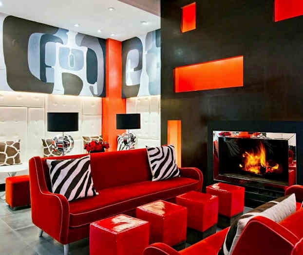 Moderni olohuone, jossa on punaiset huonekalut, takka ja koristeellisia seinämaalauksia. (Tekoälyn luoma teksti)