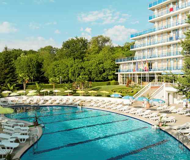 Uima-allas, jota ympäröivät aurinkotuolit ja aurinkovarjot, lähellä usean kerroksen hotellia. (Tekoälyn luoma teksti)