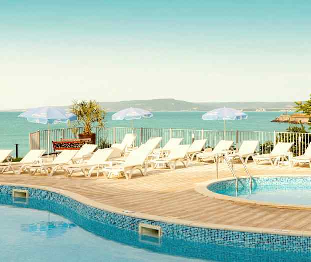 Aurinkotuoleja altaan vieressä, näkymä merelle ja maisemaan. (Tekoälyn luoma teksti)