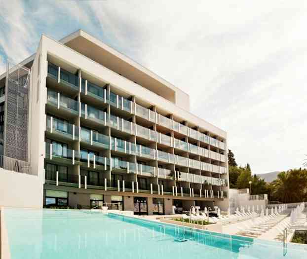 Moderni hotelli, jossa on useita parvekkeita uima-altaan edessä. (Tekoälyn luoma teksti)