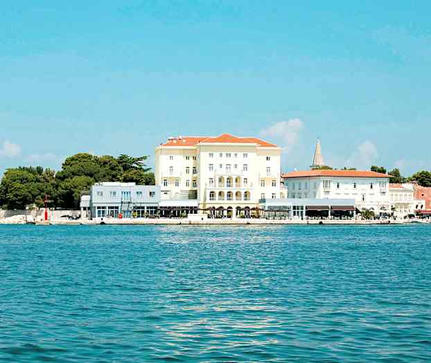 Kuva rakennuksesta rannalla, sininen meri ja kirkas taivas. (Tekoälyn luoma teksti)