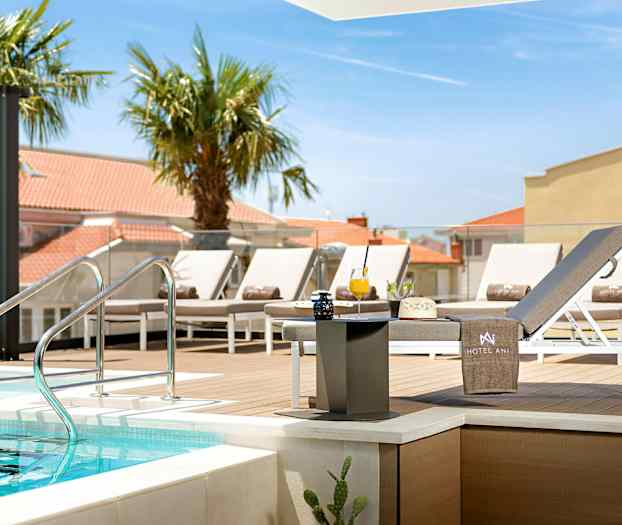 Uima-allasalue, jossa aurinkotuoleja ja pöytiä lähellä puualustaa. (Tekoälyn luoma teksti)