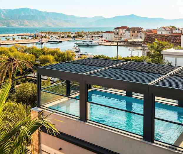 Kattoterassiallas, näkymä satamaan ja vuorille. (Tekoälyn luoma teksti)