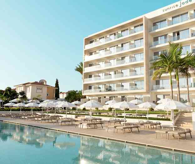 Moderni hotelli, jossa suuri ulkouima-allas, valkoisia aurinkovarjoja ja lepotuoleja. (Tekoälyn luoma teksti)