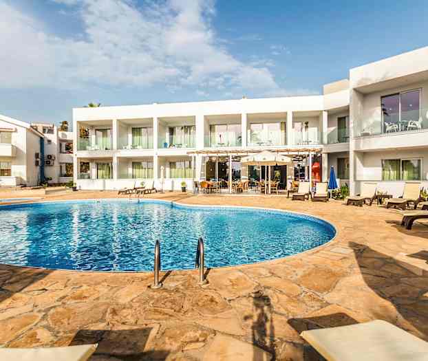 Hotellin uima-allas, ympärillä aurinkotuoleja ja pöytiä valkoiseksi maalatun rakennuksen ympäröimänä. (Tekoälyn luoma teksti)