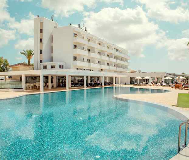 Hotelli, jossa on suuri uima-allas ja aurinkotuoleja. (Tekoälyn luoma teksti)