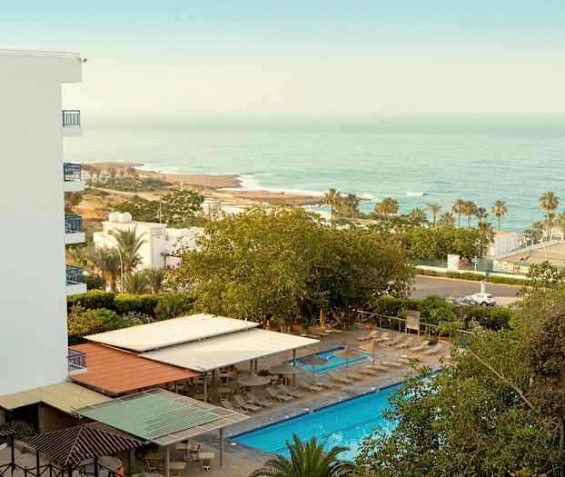 Hotellialue, jossa uima-allas, aurinkotuoleja ja merinäköala. (Tekoälyn luoma teksti)