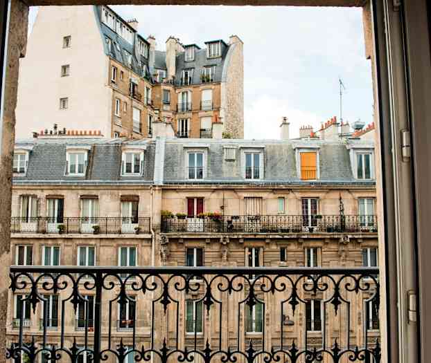 Kuva rakennuksesta, jossa parvekkeita, otettu ikkunasta, jossa on rauta-aita. (Tekoälyn luoma teksti)