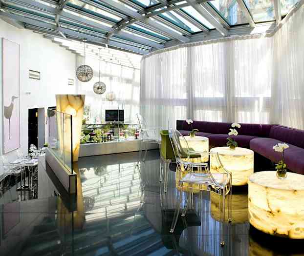 Moderni lounge, jossa lasikatto ja vaaleat istuimet. (Tekoälyn luoma teksti)