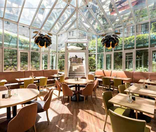 Suljettu ravintola lasiseinillä, istumapaikoilla ja valaistuksella. (Tekoälyn luoma teksti)