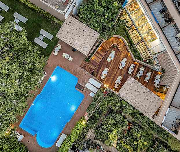 Kuva ulkouima-altaasta, aurinkotuoleista ja puuterassista istumapaikkoineen. (Tekoälyn luoma teksti)