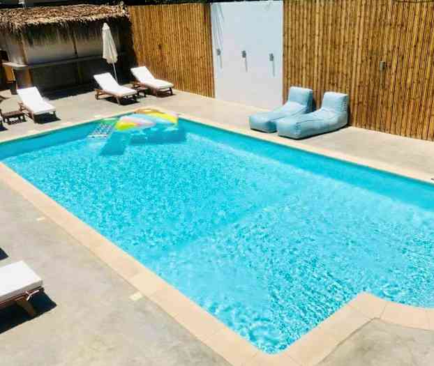 Ulkouima-allas, jossa aurinkotuoleja ja uima-lelu. (Tekoälyn luoma teksti)