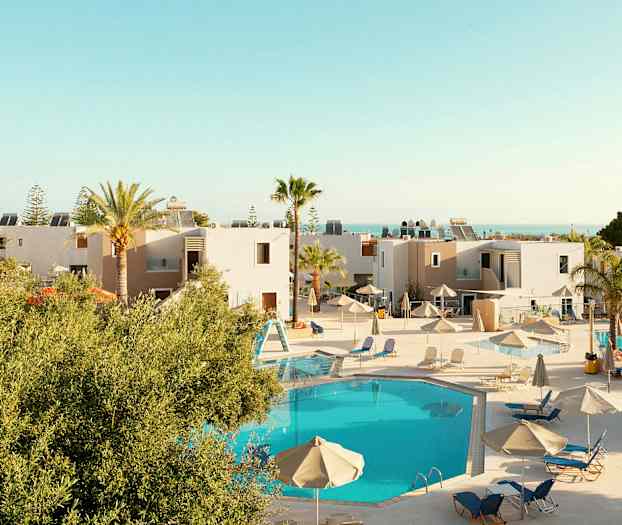 Näkymä lomakeskukseen, jossa on uima-allas ja aurinkotuoleja. (Tekoälyn luoma teksti)