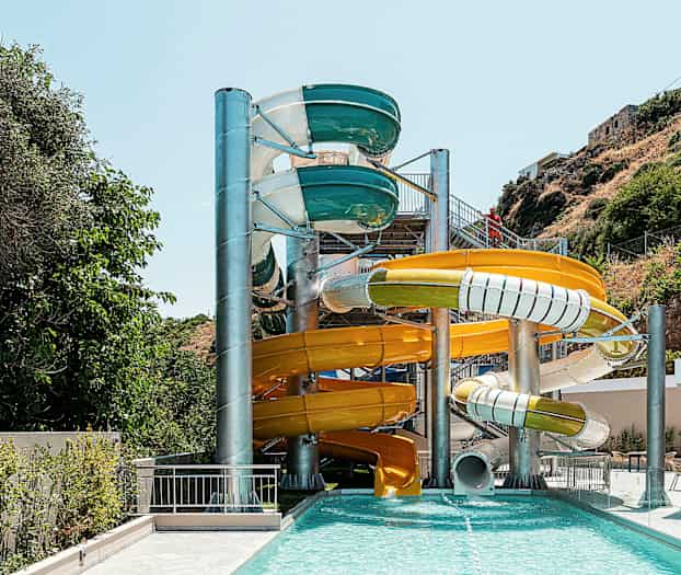 Useita värikkäitä vesiliukumäkiä ulkouima-altaalla. (Tekoälyn luoma teksti)