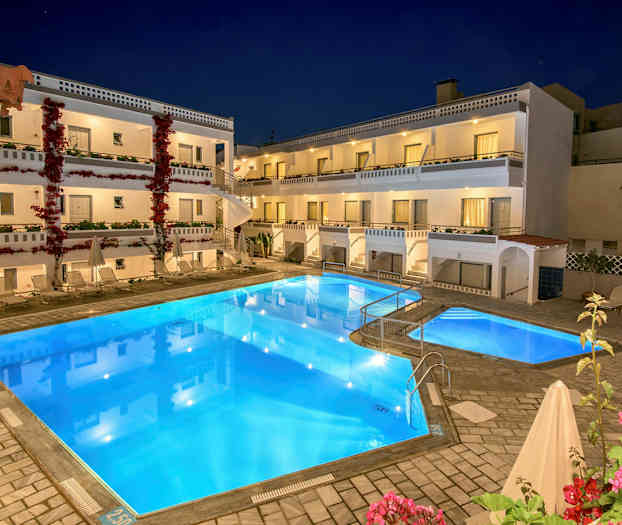 Hotelli, jossa on kolme kerrosta, uima-allas etualalla ja kukkivia kasveja. (Tekoälyn luoma teksti)