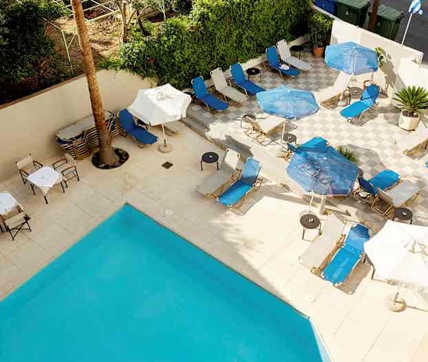 Aurinkotuoleja ja aurinkovarjoja terassilla uima-altaan ääressä. (Tekoälyn luoma teksti)