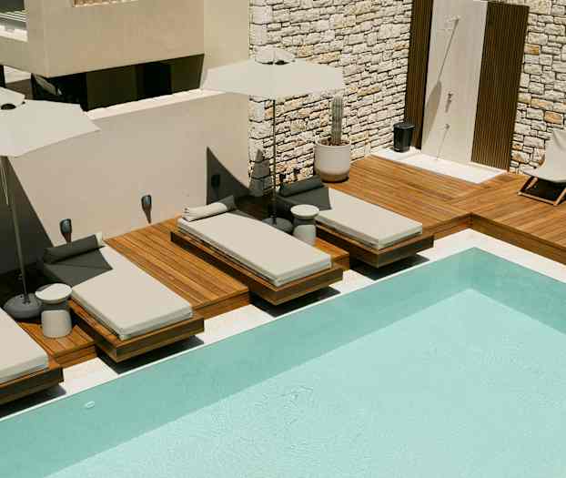 Aurinkotuoleja uima-altaan reunalla terassilla. (Tekoälyn luoma teksti)