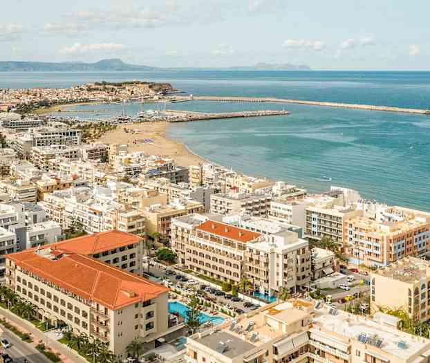 Ilmakuva rannikkokaupungista, jossa hiekkaranta ja venesatamat. (Tekoälyn luoma teksti)