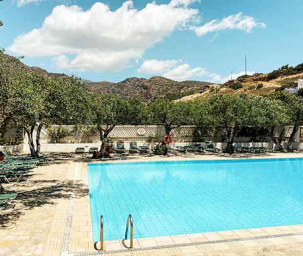 Ulkouima-allas, jonka ympärillä aurinkotuoleja ja puita kirkkaan taivaan alla. (Tekoälyn luoma teksti)