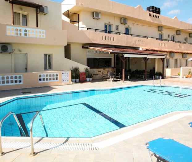 Ulkoallas hotellilla, taustalla aurinkotuoleja ja rakennus. (Tekoälyn luoma teksti)