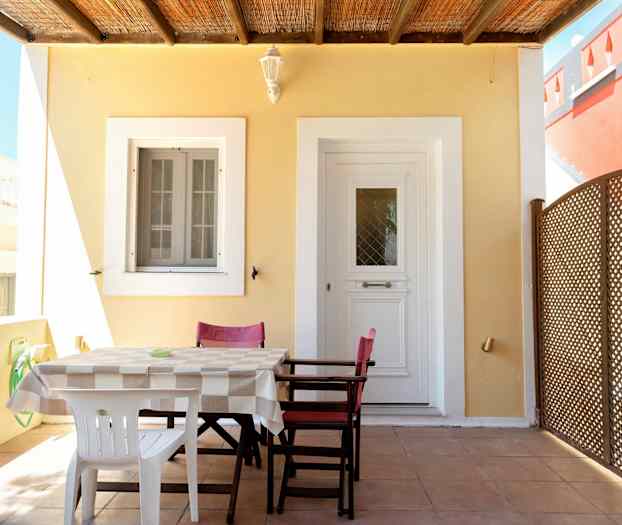 Patiolla sijaitsee pöytä ja tuoleja oven ja ikkunan edessä. (Tekoälyn luoma teksti)