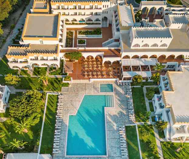 Ilmakuva lomahotellista uima-allasalueella ja ympäröivillä rakennuksilla. (Tekoälyn luoma teksti)