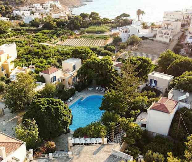 Näköala uima-altaalle, jota ympäröivät vehreys ja talot aurinkoisella alueella. (Tekoälyn luoma teksti)