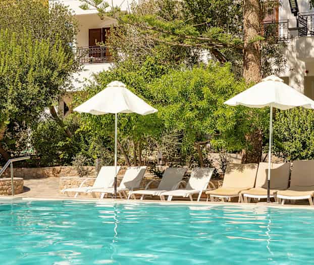 Ulkouima-allas, jossa aurinkotuoleja ja aurinkovarjoja vehreyden ympäröimänä. (Tekoälyn luoma teksti)