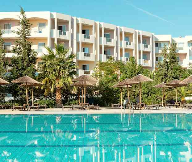 Ulkouima-allas, jonka ympärillä on päivänvarjoja ja taustalla valkoinen rakennus. (Tekoälyn luoma teksti)