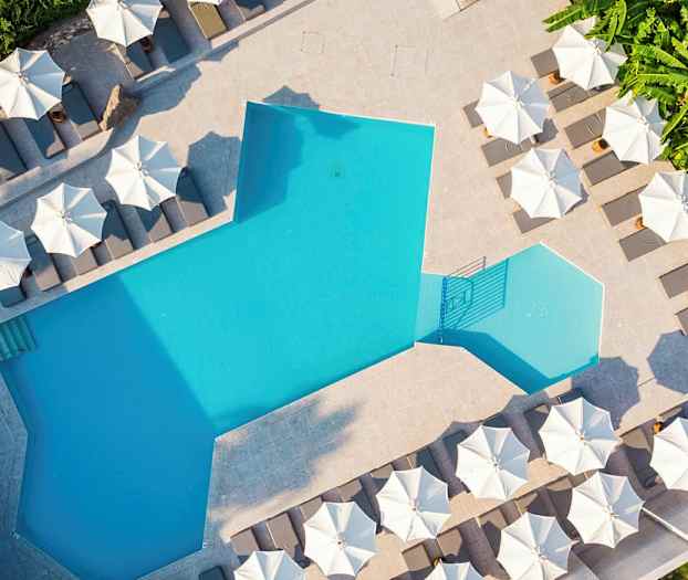 Uima-allas, jonka ympärillä on aurinkotuoleja ja aurinkovarjoja. (Tekoälyn luoma teksti)