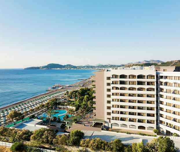 Näkymä hotellirakennuksesta lähellä hiekkarantaa ja merta aurinkotuoleineen ja aurinkovarjoineen. (Tekoälyn luoma teksti)