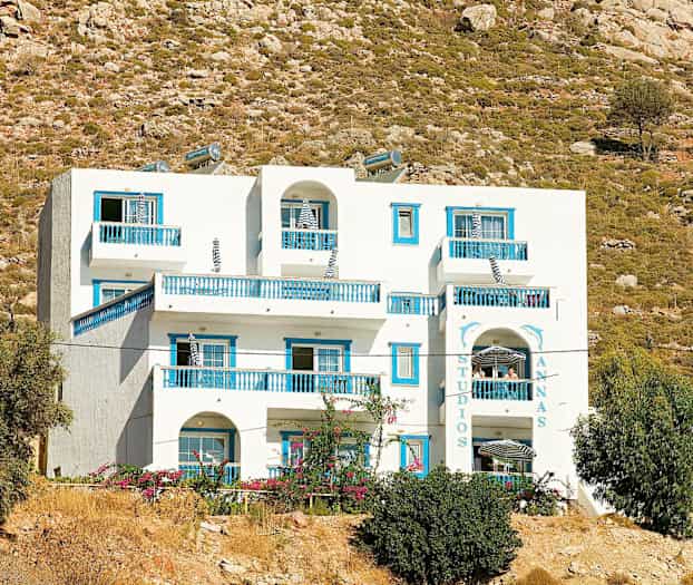 Valkoinen rakennus, jossa sinisiä yksityiskohtia, karun maiseman taustalla. (Tekoälyn luoma teksti)