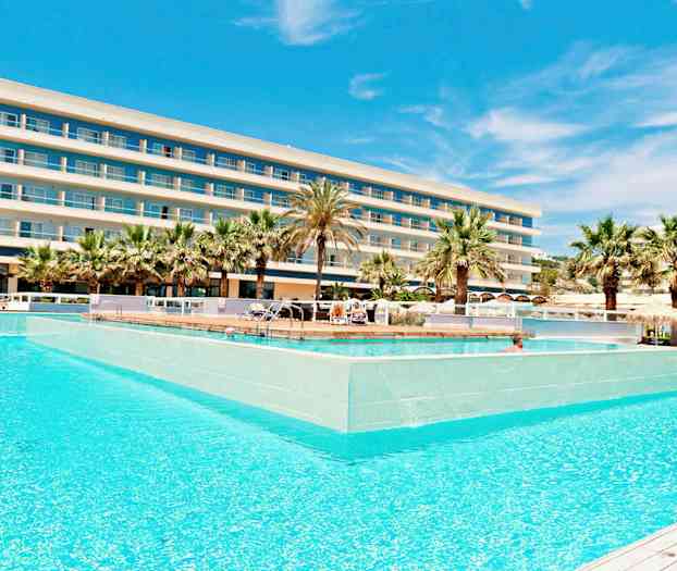 Hotelli, jossa on useita kerroksia, suuren uima-altaan takana, jota ympäröivät palmut. (Tekoälyn luoma teksti)