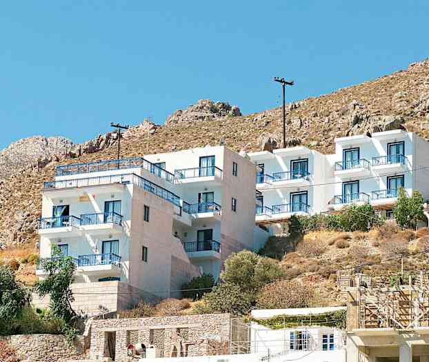 Valkoinen rakennus sinisillä parvekekaiteilla vuorenrinteessä. (Tekoälyn luoma teksti)