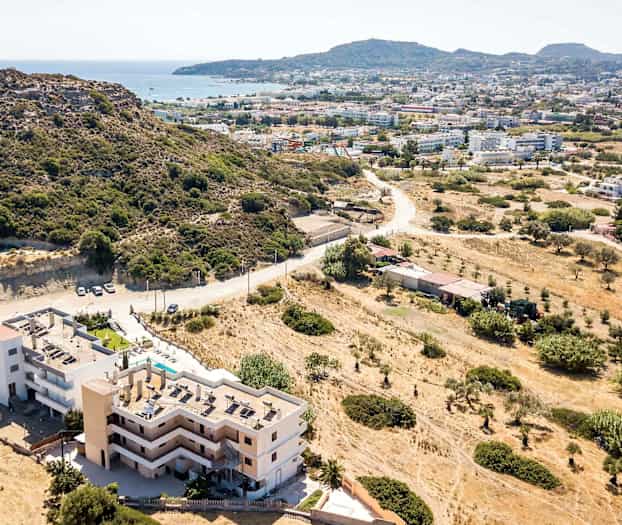 Ilmakuva rakennuksesta lähellä vuorenrinnettä, näkymä kaupunkiin ja merelle. (Tekoälyn luoma teksti)