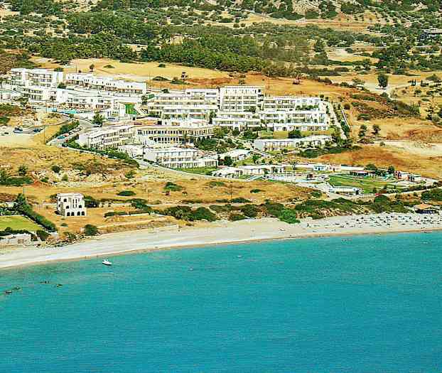 Näkymä hotellien ja rakennusten rinteestä lähellä rantaa, jossa on aurinkotuoleja ja sininen meri. (Tekoälyn luoma teksti)