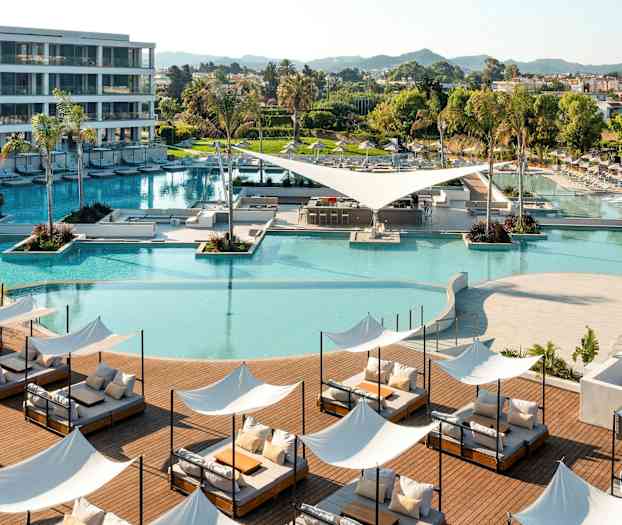 Moderni lomakohde, jossa uima-allas, aurinkotuoleja ja vihreitä alueita. (Tekoälyn luoma teksti)