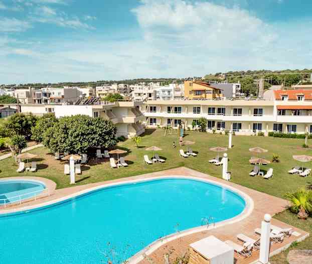 Kuva uima-altaasta, jossa on aurinkotuoleja ja varjoja nurmikolla, ympäröitynä rakennuksilla. (Tekoälyn luoma teksti)