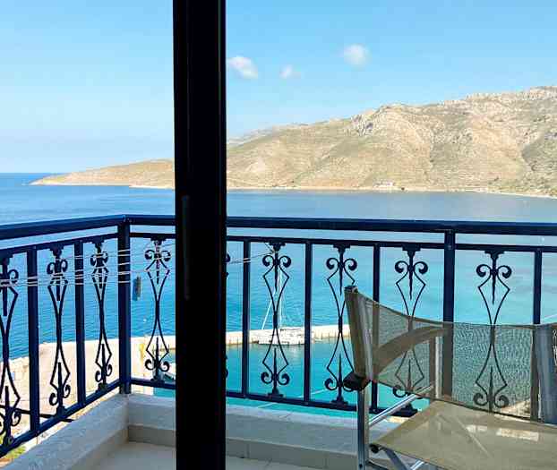 Näkymä parvekkeelta, etualalla tuolin selkänoja, merelle ja vuorille kaukana. (Tekoälyn luoma teksti)