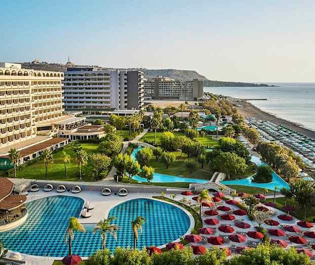 Hotellikompleksi, jossa uima-altaita, viheralueita ja ranta. (Tekoälyn luoma teksti)