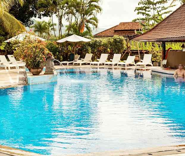 Ulkouima-allas, jota ympäröivät aurinkotuolit ja aurinkovarjot. (Tekoälyn luoma teksti)