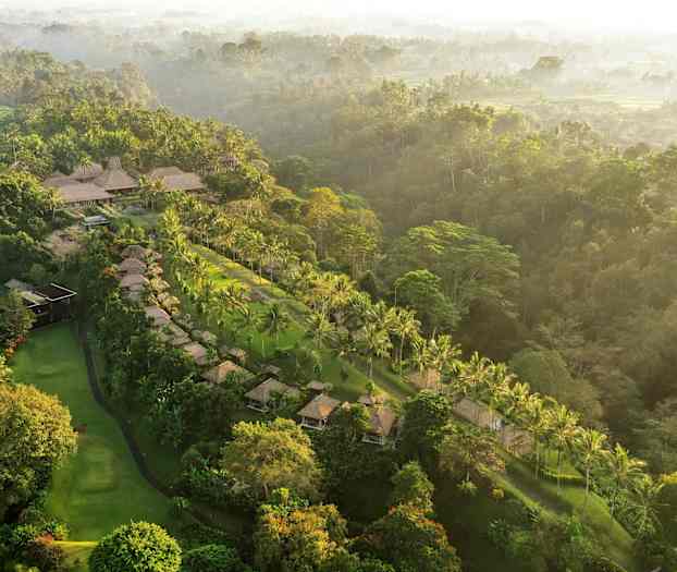Ilmakuva trooppisesta maisemasta, jossa on palmuja, majoituksia ja vehreyttä. (Tekoälyn luoma teksti)