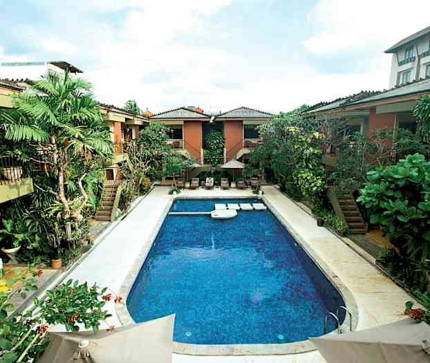 Kuva ulkoaltaasta, jota ympäröi trooppinen kasvillisuus ja rakennukset. (Tekoälyn luoma teksti)