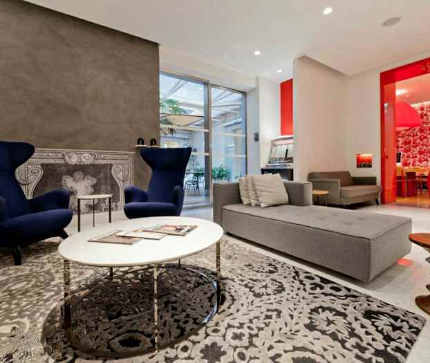 Modernisti sisustettu olohuone, jossa nojatuoleja, sohva ja koristeellinen takka. (Tekoälyn luoma teksti)