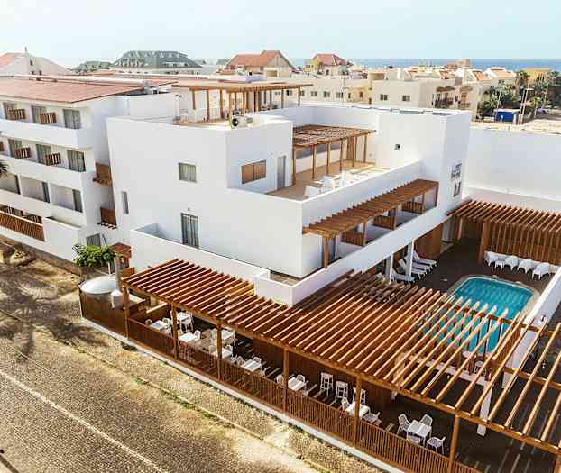 Kerrostalon valkoinen julkisivu, puuyksityiskohtia ja ulkouima-allas. (Tekoälyn luoma teksti)