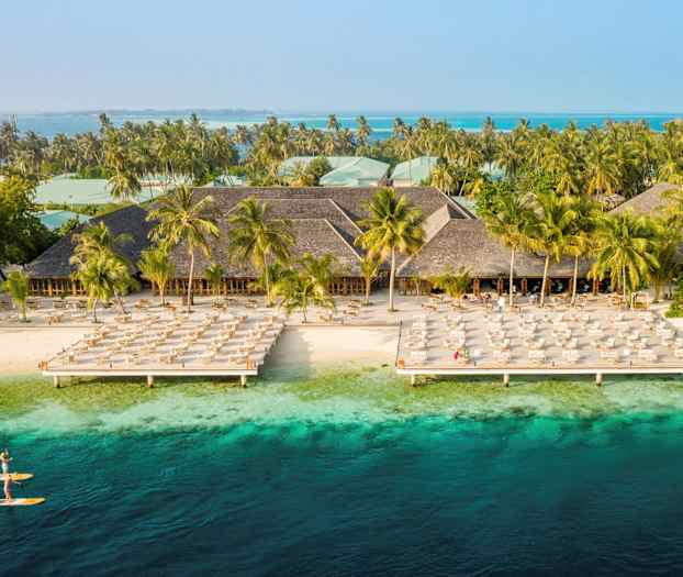 Hotellialue rannalla aurinkotuoleineen ja turkoosinsinisine vesineen. (Tekoälyn luoma teksti)